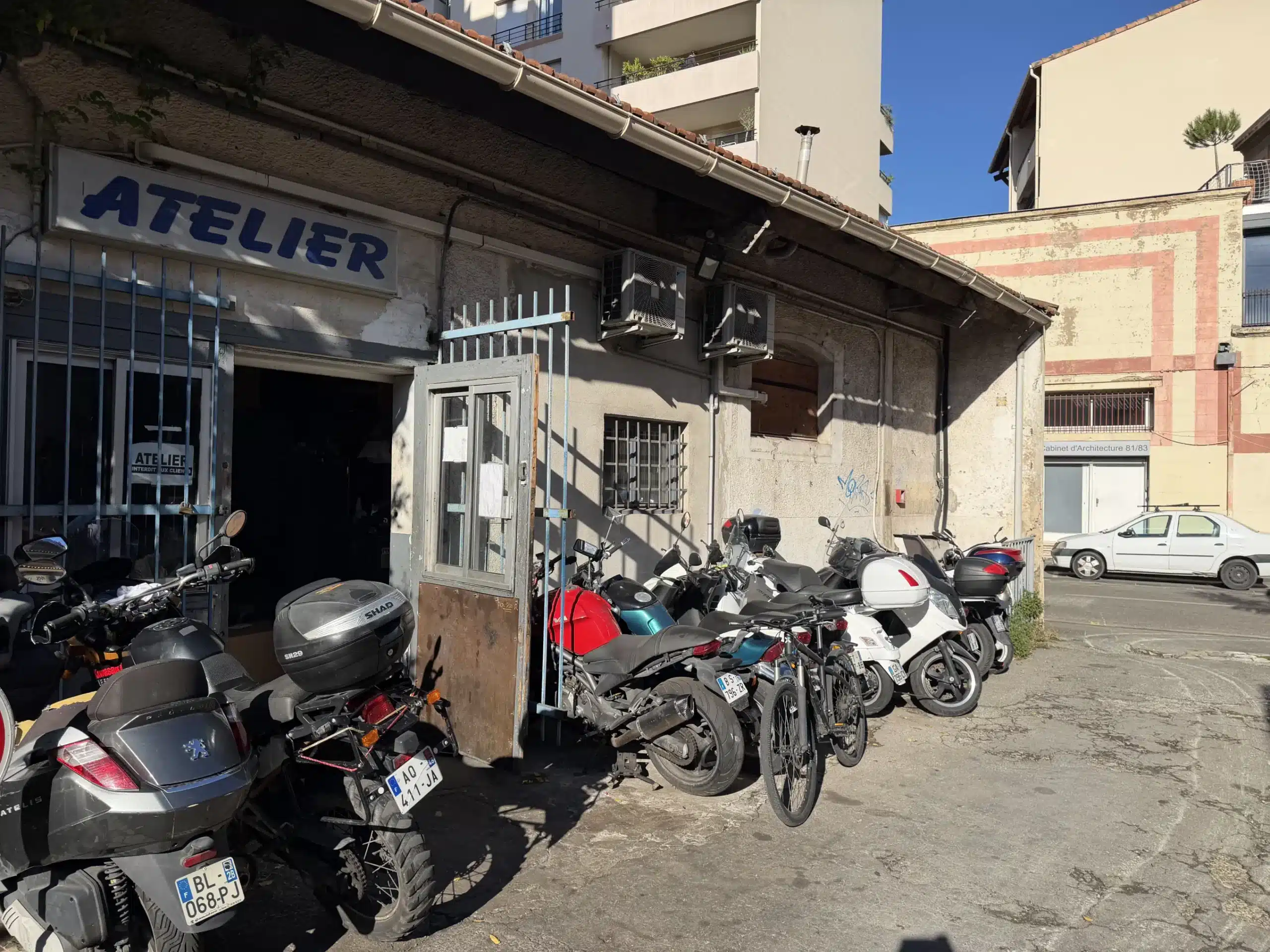 Garage moto et scooter à Marseille - Atelier avec motos garées à l'extérieur.